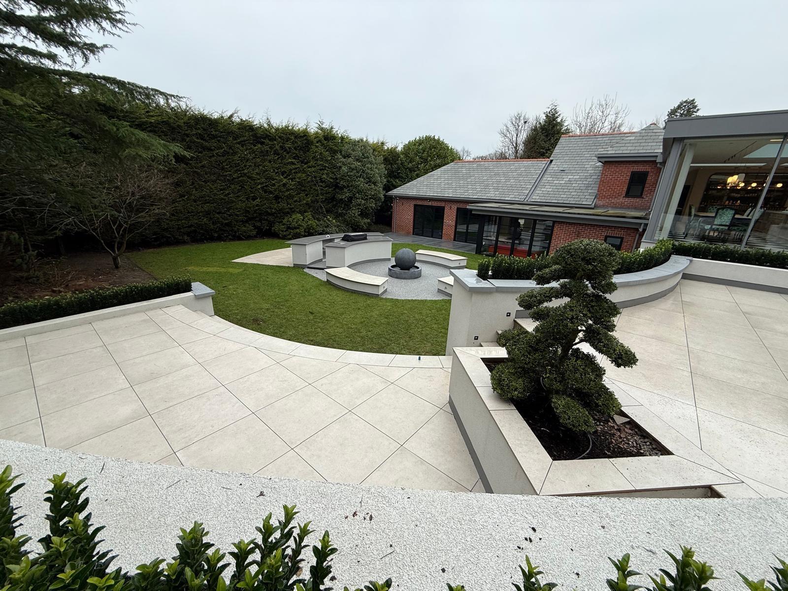 Circular garden with stone seating and water feature finished by Pavedway