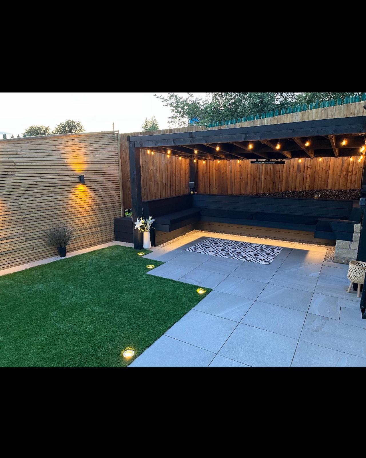 Garden pergola with string lighting and built-in seating at dusk