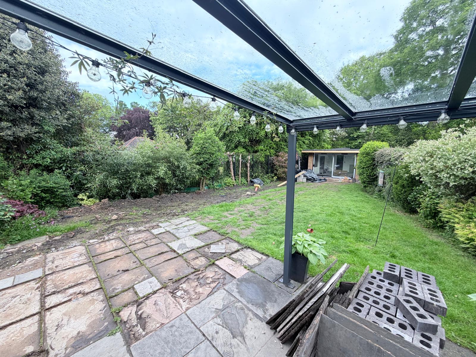 Tired patio and lawn under an existing veranda, before garden renovation