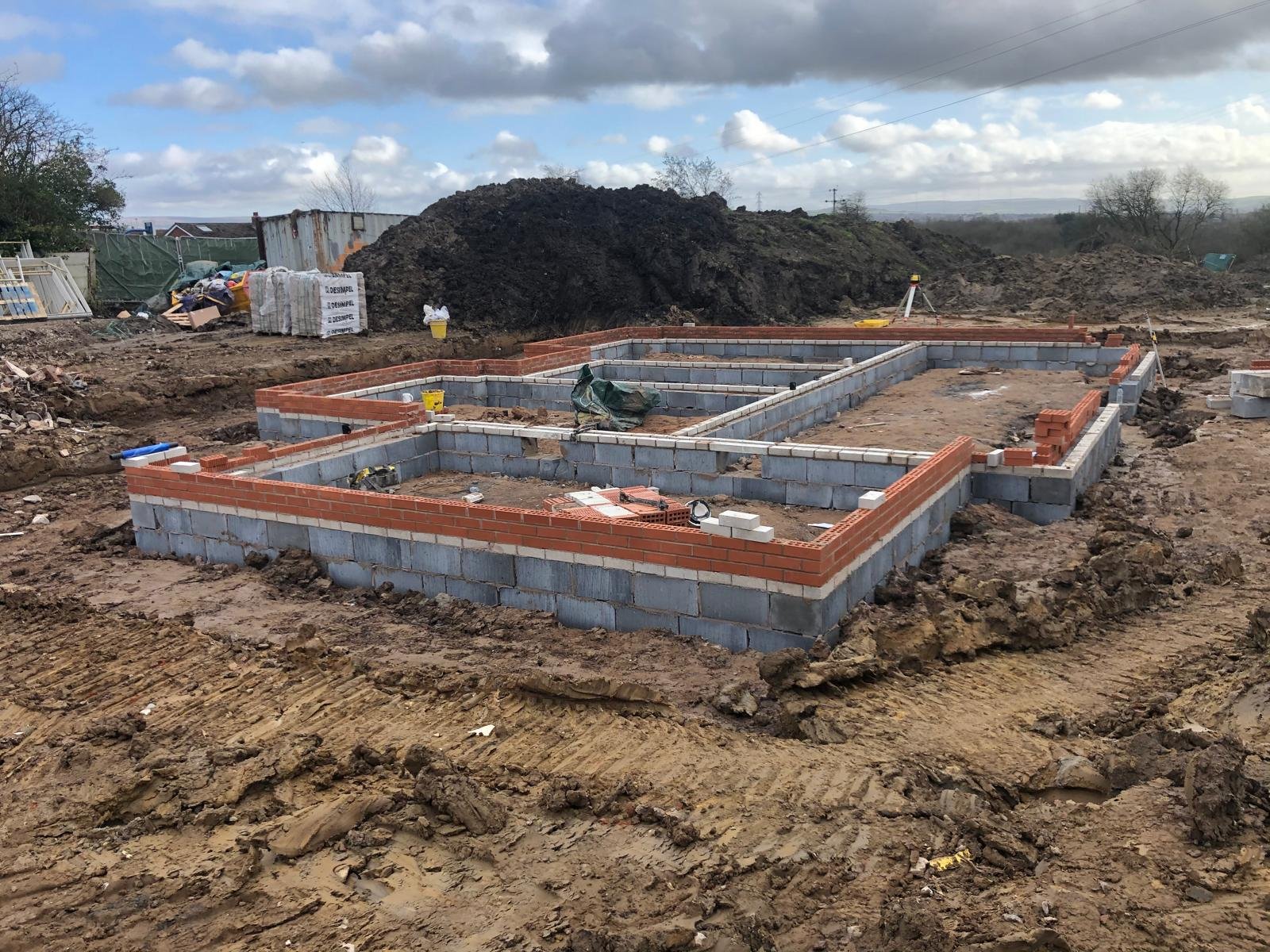 Brick and block foundation walls complete, forming the full footprint of a new build