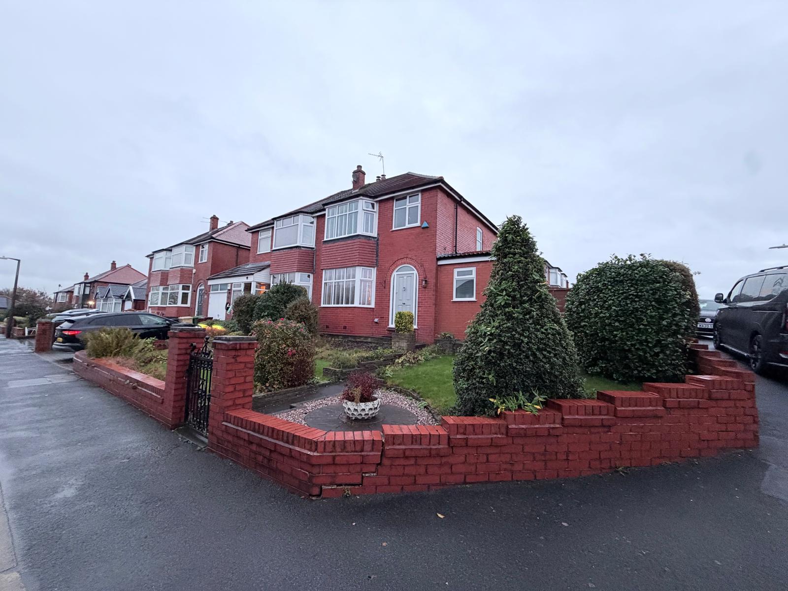 Front garden before resin driveway with a cracked and leaning brick wall